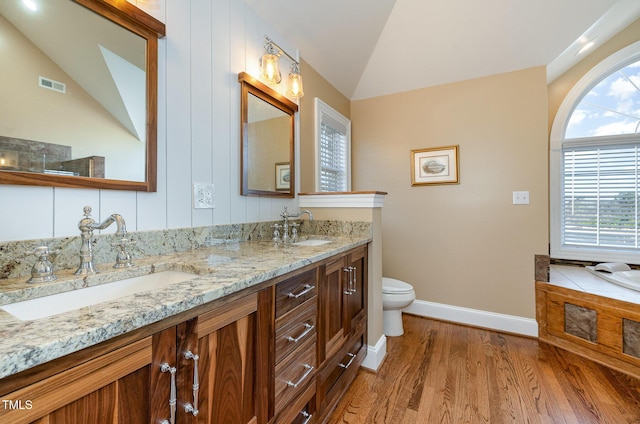 bathroom with lofted ceiling, toilet, hardwood / wood-style floors, and vanity