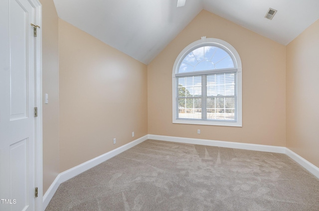 carpeted spare room with lofted ceiling