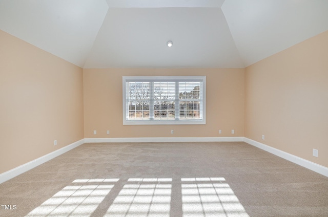 carpeted empty room featuring lofted ceiling