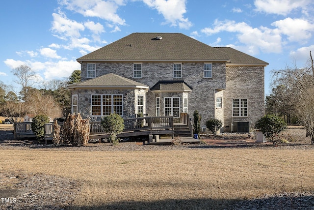 rear view of property with a yard, central air condition unit, and a deck