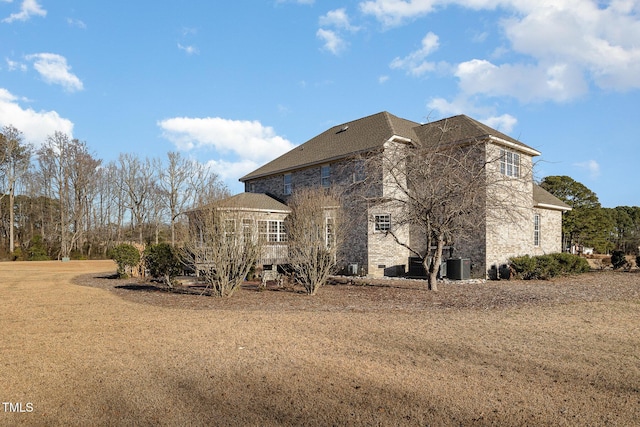 exterior space featuring cooling unit and a lawn