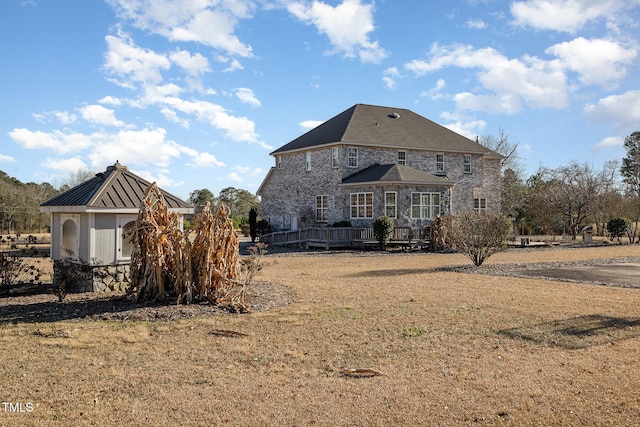 rear view of property featuring a wooden deck and a yard