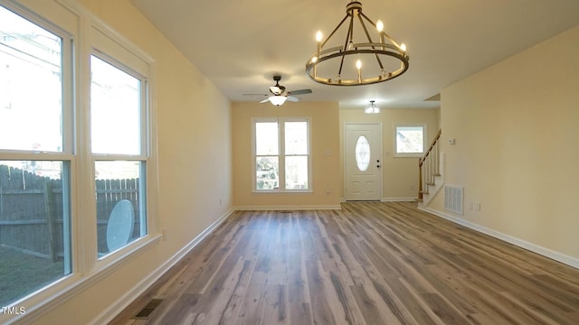 interior space featuring ceiling fan with notable chandelier and hardwood / wood-style floors