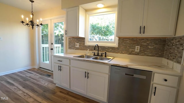 kitchen with sink, white cabinetry, decorative light fixtures, light wood-type flooring, and stainless steel dishwasher