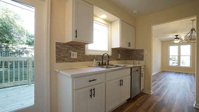 kitchen with hanging light fixtures, sink, stainless steel dishwasher, and white cabinets