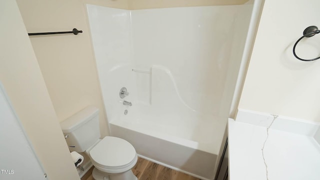 bathroom featuring shower / bathing tub combination, wood-type flooring, and toilet