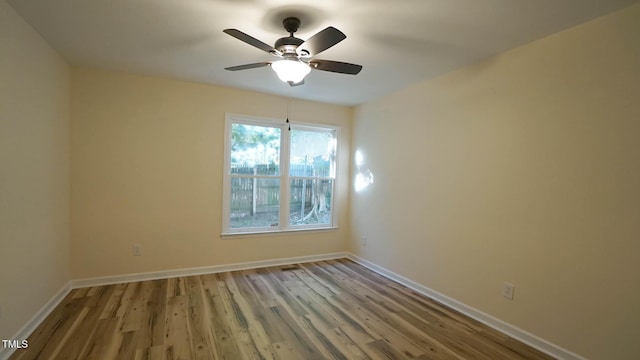 spare room with ceiling fan and light wood-type flooring