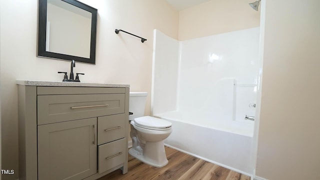 full bathroom with vanity, wood-type flooring, bathing tub / shower combination, and toilet