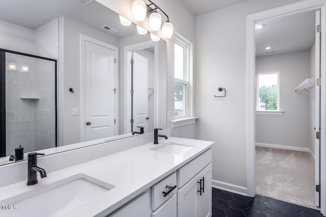 bathroom with tile patterned flooring, vanity, and walk in shower