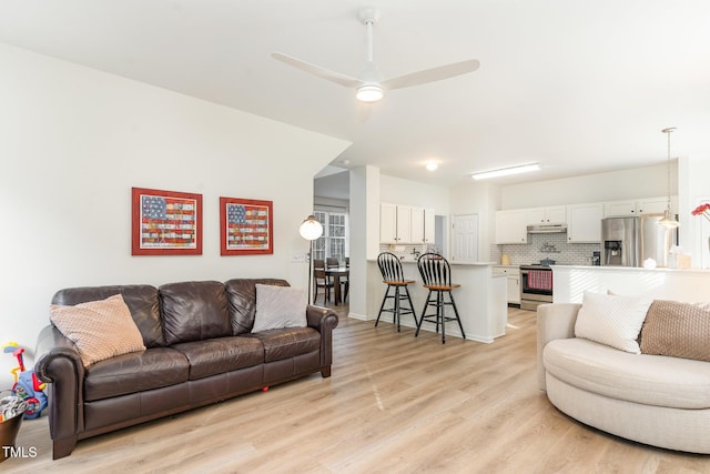 living room featuring ceiling fan and light hardwood / wood-style flooring