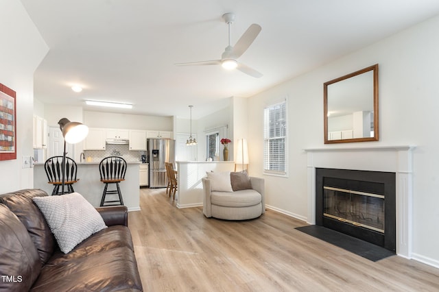 living room featuring light hardwood / wood-style flooring and ceiling fan