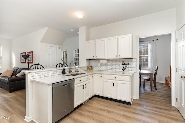 kitchen featuring white cabinetry, dishwasher, sink, and kitchen peninsula