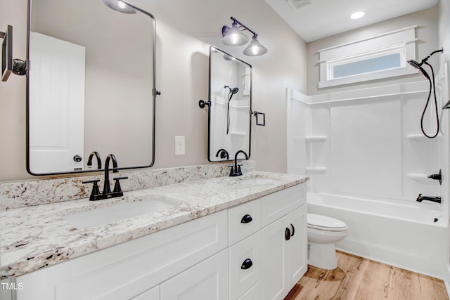 full bathroom with hardwood / wood-style flooring, vanity, toilet, and bathtub / shower combination