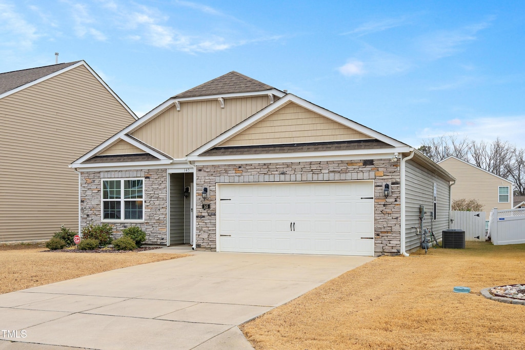 view of front of property with a garage and central AC unit