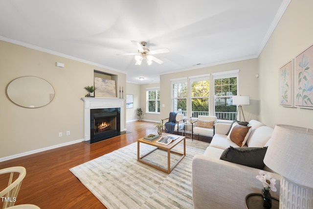 living room with hardwood / wood-style flooring, crown molding, and ceiling fan