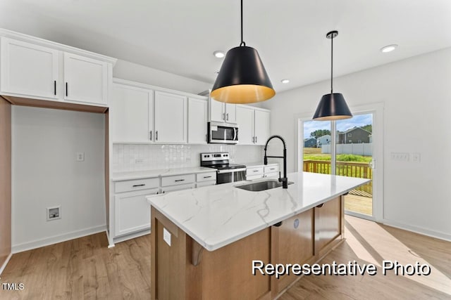 kitchen featuring sink, stainless steel appliances, an island with sink, and white cabinets