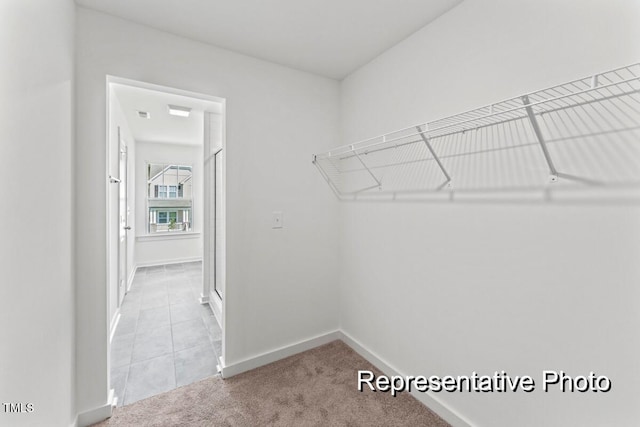 walk in closet featuring light carpet