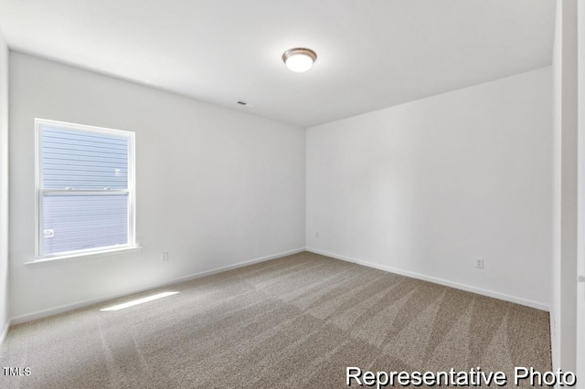 spare room with carpet floors and baseboards