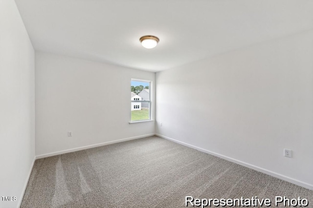 carpeted spare room featuring baseboards