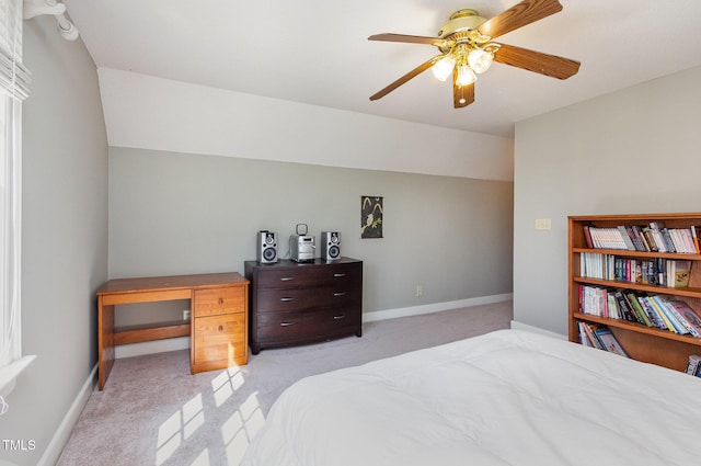 bedroom featuring vaulted ceiling, light colored carpet, and baseboards