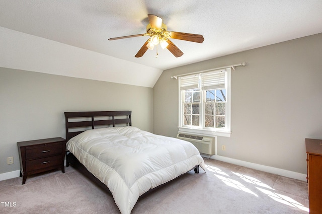 bedroom with a ceiling fan, baseboards, a wall mounted AC, vaulted ceiling, and light carpet