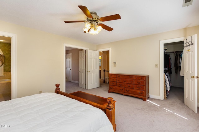 bedroom featuring visible vents, a closet, connected bathroom, light colored carpet, and a spacious closet