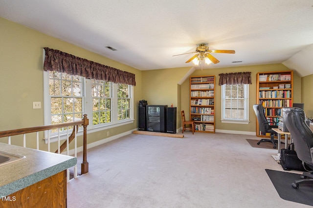 office with visible vents, plenty of natural light, light colored carpet, and ceiling fan