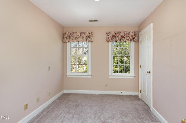 unfurnished room featuring light carpet, visible vents, and baseboards