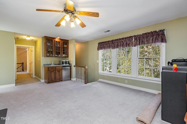 kitchen with baseboards, visible vents, glass insert cabinets, light carpet, and stainless steel dishwasher