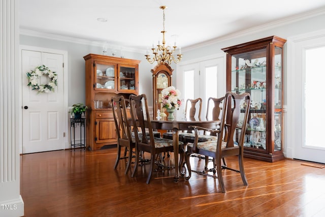 dining room featuring an inviting chandelier, dark hardwood / wood-style flooring, and ornamental molding