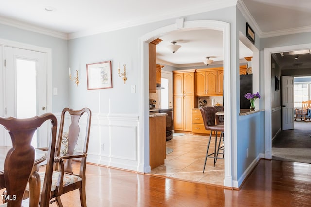 dining room with crown molding and light hardwood / wood-style flooring