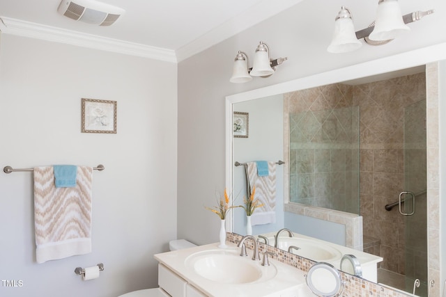 bathroom featuring crown molding, toilet, vanity, and a shower with shower door