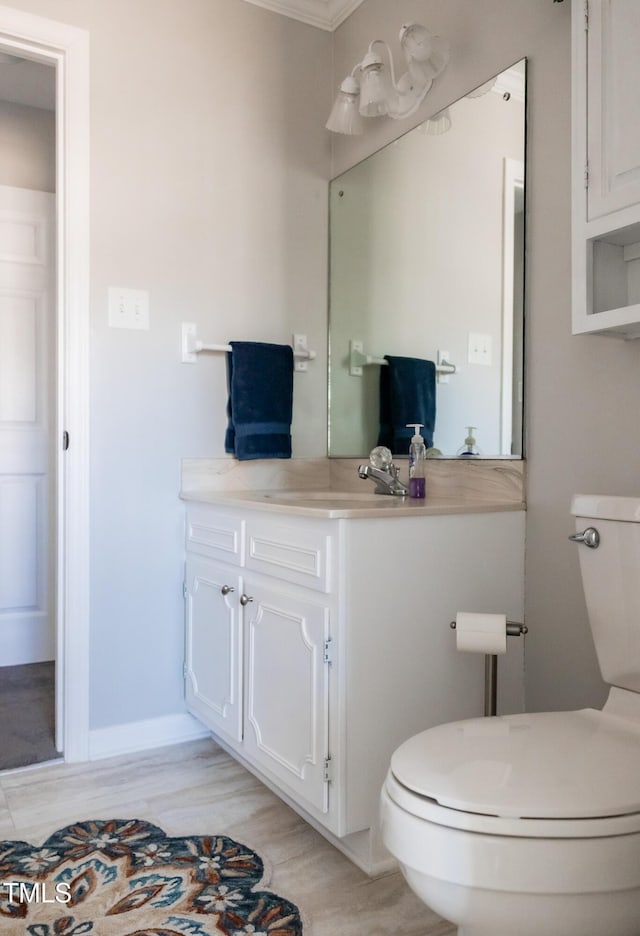 bathroom featuring vanity, hardwood / wood-style flooring, crown molding, and toilet