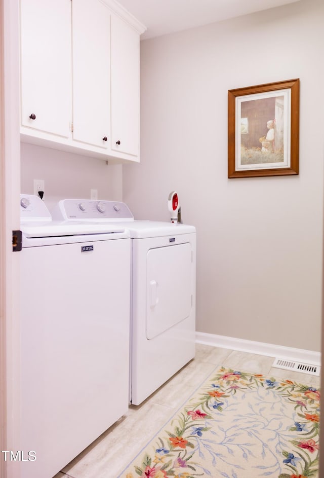 laundry room with cabinets and washing machine and clothes dryer