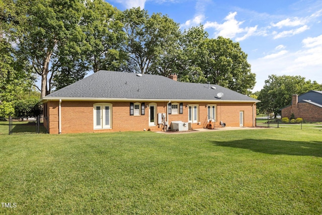 back of property featuring central AC, a lawn, and a patio area