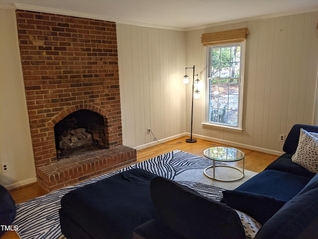 living room featuring crown molding, a fireplace, and light hardwood / wood-style floors