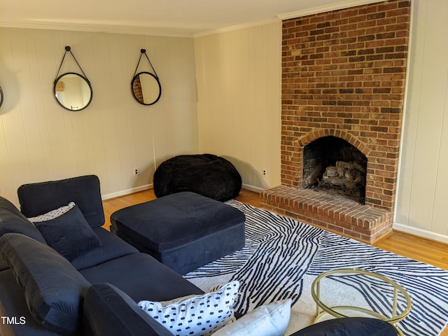 living room featuring a brick fireplace, crown molding, and light wood-type flooring