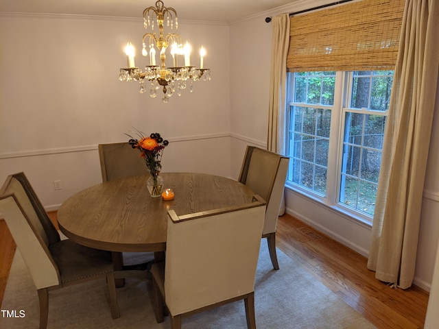 dining area featuring crown molding, hardwood / wood-style flooring, a chandelier, and a healthy amount of sunlight