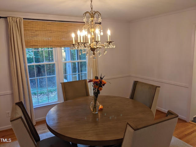 dining room with wood-type flooring, a chandelier, and crown molding