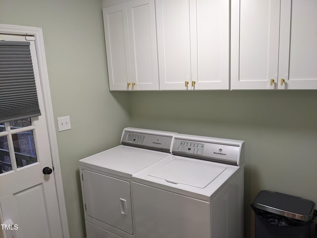 clothes washing area with cabinets and washer and dryer