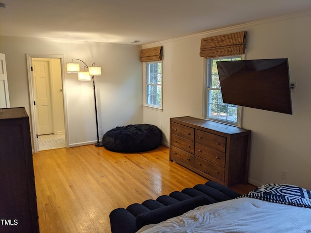 bedroom with crown molding and light hardwood / wood-style flooring