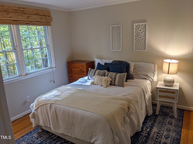 bedroom with wood-type flooring and ornamental molding