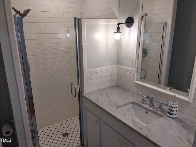 bathroom with vanity, decorative backsplash, and a shower with shower door