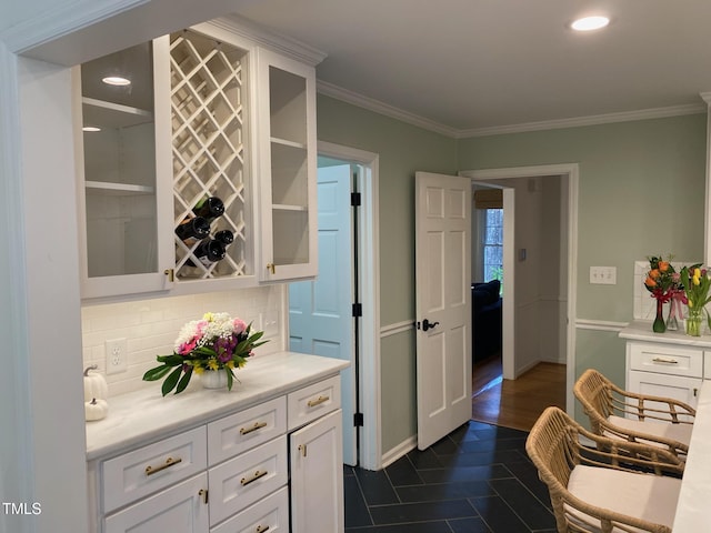 bar with white cabinetry, ornamental molding, and tasteful backsplash