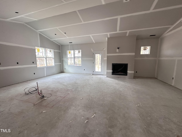 unfurnished living room featuring vaulted ceiling