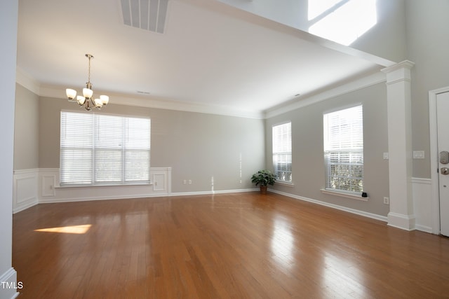 unfurnished living room featuring crown molding, a chandelier, and hardwood / wood-style floors