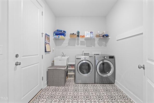 laundry room with sink, light tile patterned floors, and washer and clothes dryer