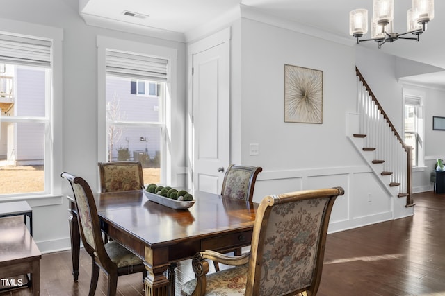 dining room featuring a notable chandelier, dark wood-type flooring, and ornamental molding