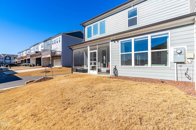 back of house with a yard and a sunroom