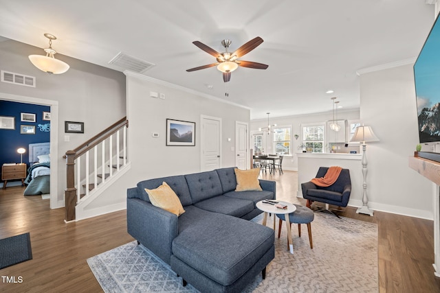 living room with stairs, ornamental molding, wood finished floors, and visible vents